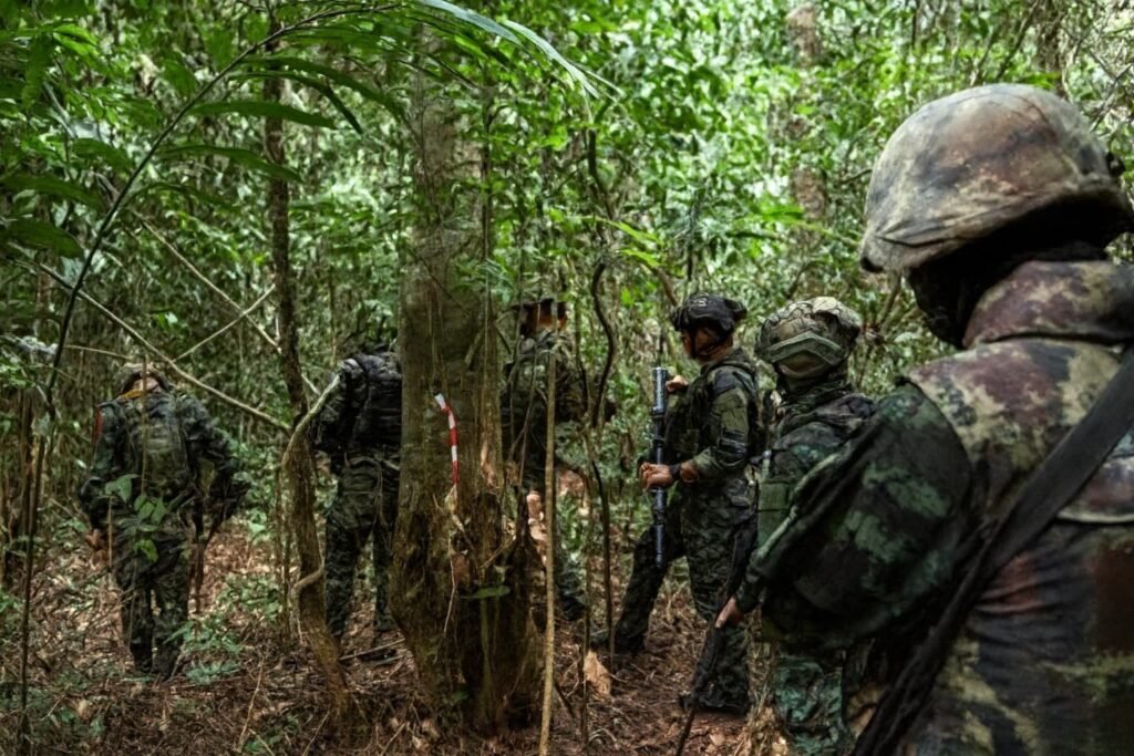 hai soldiers standing guard on a rural road overlooking the disputed Thai–Cambodian border area following renewed fighting.