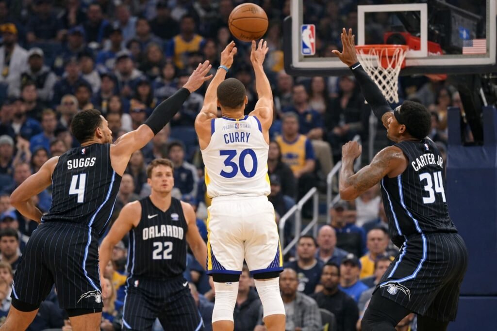 Stephen Curry attempts a three-point shot against the Orlando Magic defense