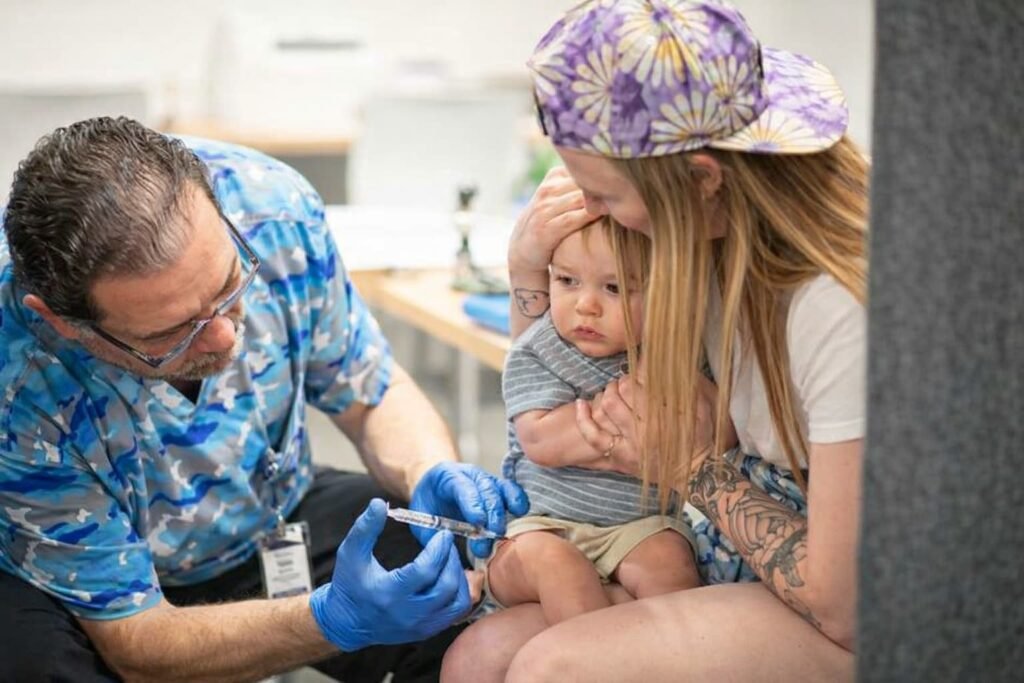 Child examined by doctor for measles rash