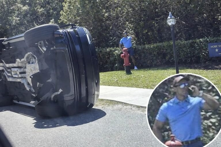 Tiger Woods standing next to overturned black Land Rover SUV after rollover crash on Jupiter Island Florida on March 27 2026 before DUI arrest