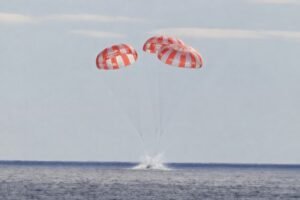NASA Artemis II Orion spacecraft Integrity with four astronauts descending on parachutes toward Pacific Ocean off San Diego during splashdown April 10 2026