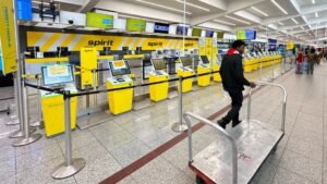 Empty Spirit Airlines ticket counter at Fort Lauderdale Hollywood International Airport with cancellation notice taped to kiosk as airline ceases all operations May 2 2026