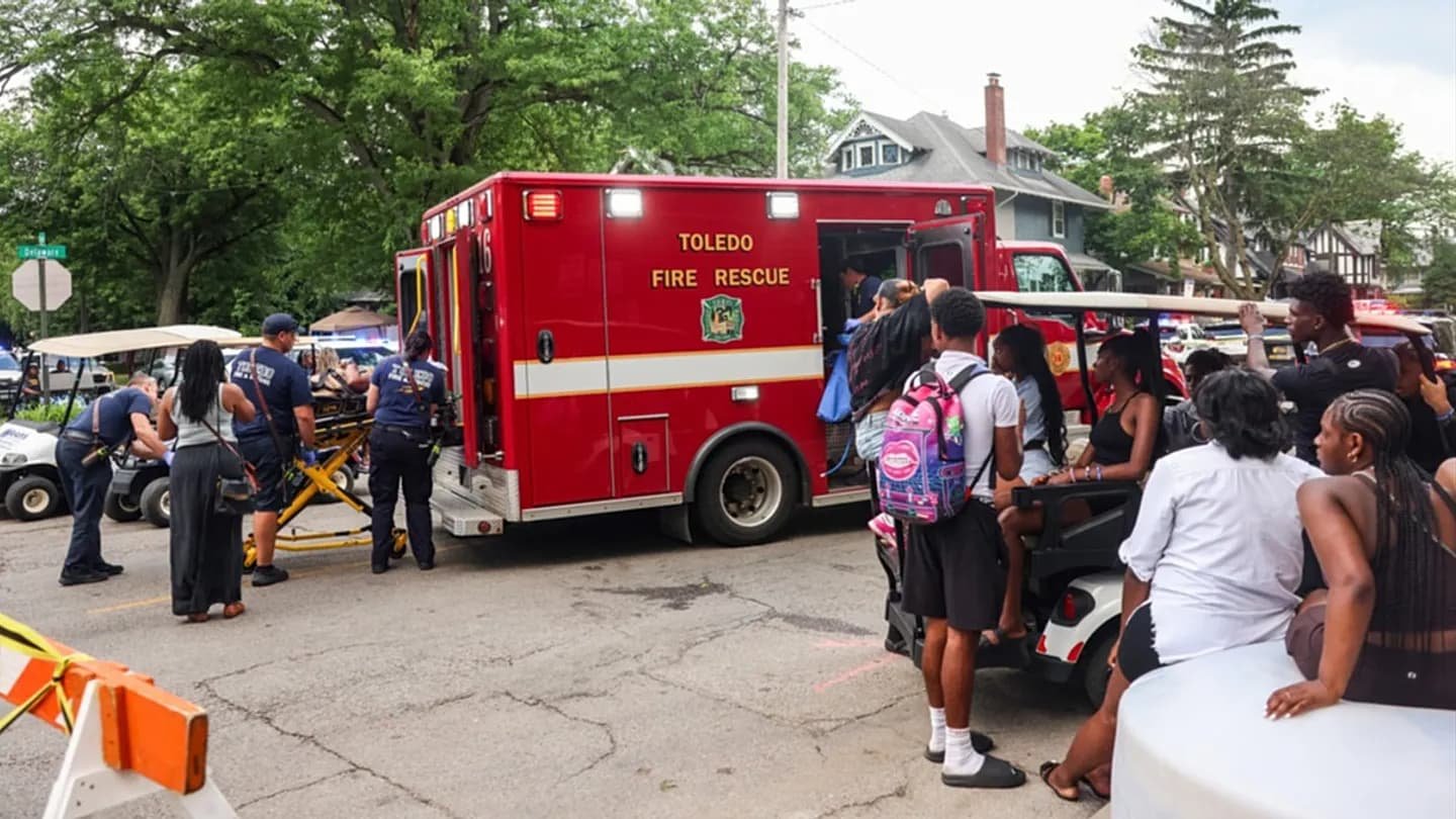 Police officers standing near Agnes Reynolds Jackson Arboretum where multiple people were shot at Toledo Ohio's Old West End Festival on June 6 2026 leaving 12 wounded and two critical